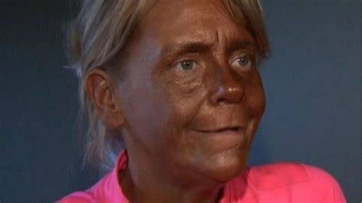 Tanning addict Tan Mom blends into brown couch in wild photo